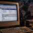 Vintage computer showing the ILOVEYOU virus email with a digital map highlighting its global spread from the Philippines.